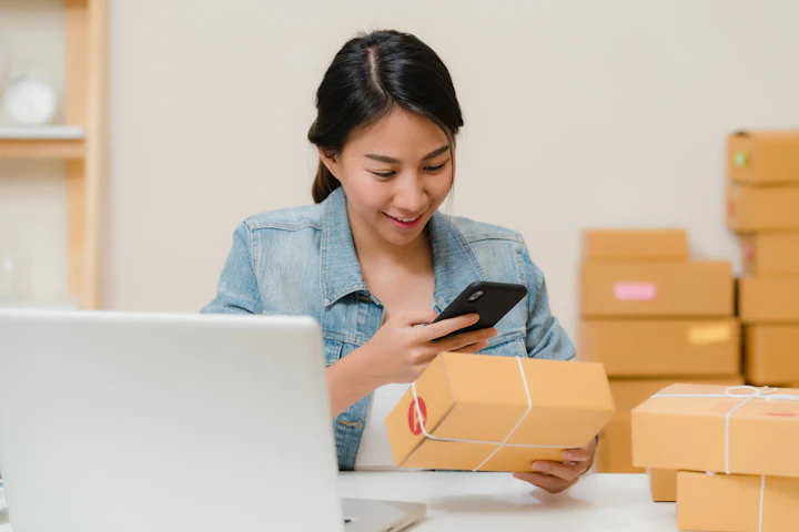 A business owner checking a parcel beside a laptop