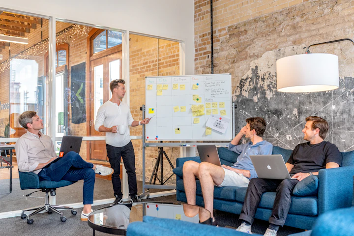 Colleagues discussing ideas beside a whiteboard